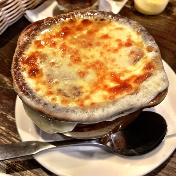 A bubbling crock of French onion soup with melted, golden-brown cheese on top, served at Sommer's Place.