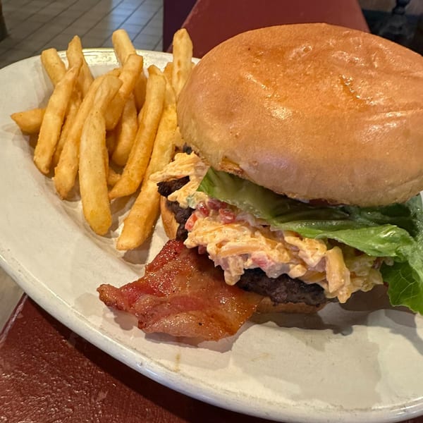 A Sommer's Place southern burger with pimento cheese, bacon, lettuce, and a side of fries.